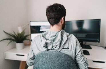 man in gray hoodie sitting on chair